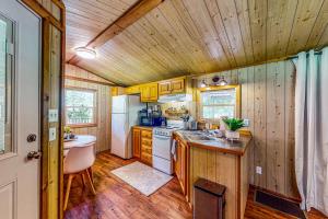 cocina con paredes de madera y suelo de madera en The Cabin at Monaville, 