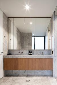 uma casa de banho com um lavatório e um espelho grande em Alfred & Turner Apartments, Luxury 2 Bedroom Condos in heart of the Valley em Brisbane