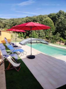 un parasol rouge, des chaises et une piscine dans l'établissement Quinta do Borges, à Guarda