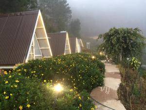 a row of houses with yellow flowers and trees at Tuyết Hoa Hòn Bồ Homestay in Da Lat