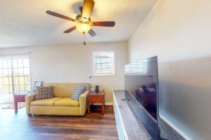 a living room with a couch and a ceiling fan at Gators, Fishes, Beaches, and Birds in Freeport