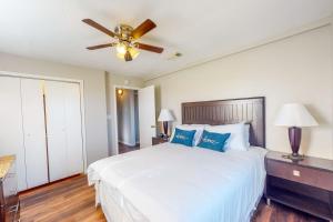 a bedroom with a white bed with a ceiling fan at Gators, Fishes, Beaches, and Birds in Freeport