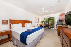 sypialnia z dużym łóżkiem i telewizorem w obiekcie The Coast Beachfront Hotel w mieście Tamarindo