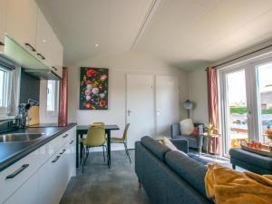 cocina y sala de estar con sofá y mesa en Grote Karekiet 24-22, en Breukelen