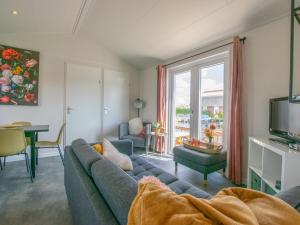 ein Wohnzimmer mit einem blauen Sofa und einem TV in der Unterkunft Grote Karekiet 24-22 in Breukelen