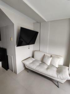 馬尼拉的住宿－Monalisa Gilmore Tower，带平面电视的客房内的白色沙发