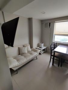 馬尼拉的住宿－Monalisa Gilmore Tower，客厅配有白色的沙发和桌子