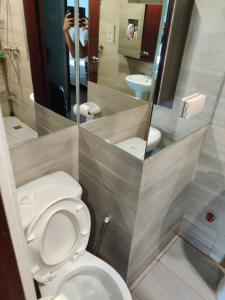 馬尼拉的住宿－Monalisa Gilmore Tower，一间带卫生间的浴室和一个拍照的人