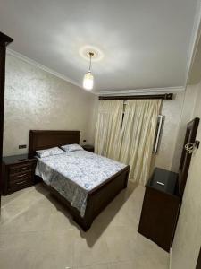 una camera con un letto e due tavoli e una finestra di Appartement boulaàyoun de luxe à louer nador 2 a Nador