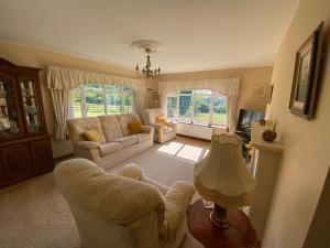 a living room with two chairs and a couch at Bedw Arian Cottage in Benllech