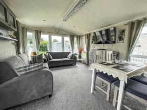 a living room with a couch and a table at Lovely Wheelchair Friendly Caravan At Skipsea Sands In Yorkshire Ref 41167wf in Barmston