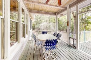 una veranda riparata con tavolo e sedie di Suwanee House & Riverbend a Bell
