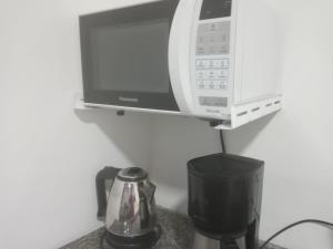 a microwave sitting on a shelf next to a blender at Deslumbrante Apartamento Central in Curitiba
