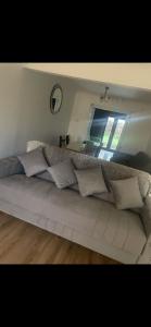 a couch with pillows in a room with a mirror at 5 bedroom modern detached house in Morriston