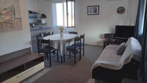 a room with a table and chairs and a kitchen at Apartment Kraj 8372b in Tkon +12 photos