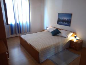a bedroom with a bed in a room with windows at Apartment Kraj 8372b in Tkon