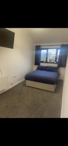 a bedroom with a blue bed and a window at 5 bedroom modern detached house in Morriston