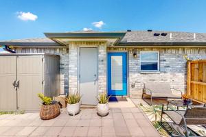 a brick house with a blue door and a patio at Pineywood Hollow in Harlingen