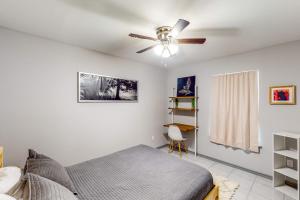 een slaapkamer met een plafondventilator en een bed bij Pineywood Hollow in Harlingen