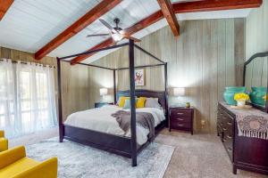 1 dormitorio con cama con dosel y ventilador de techo en The Fern Cabin, en Centralia