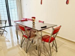 mesa de comedor con sillas rojas y lámpara. en Vow en Villa Carlos Paz