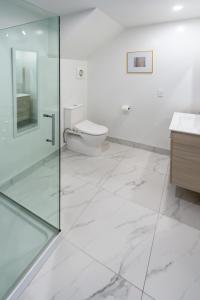 a bathroom with a glass shower and a toilet at Large trendy 3 Bedroom Residence, Central City in Christchurch +21 photos