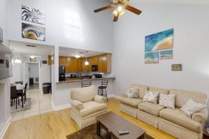 a living room with a couch and a kitchen at Sugar Berry Suites in Tallahassee