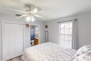 a white bedroom with a ceiling fan and a bed at Sugar Berry Suites in Tallahassee