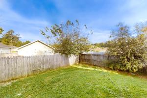 a backyard with a wooden fence and a yard at Sugar Berry Suites in Tallahassee