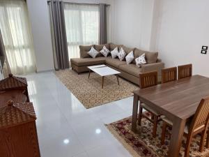 a living room with a couch and a table at شقه عصريه in Madinat Al Ashir min Ramadan