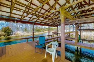 a porch with two chairs and a table and chairs at Satterfield Boathouse in Donalsonville
