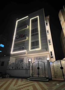 un edificio con una valla delante de él por la noche en شقه عصريه, en Madinat Al Ashir min Ramadan