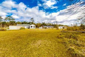 een groot veld met een huis op de achtergrond bij Satterfield Boathouse in Donalsonville