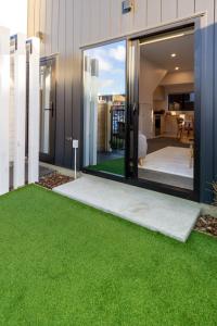 a garden with green grass in front of a house at Large trendy 3 Bedroom Residence, Central City in Christchurch