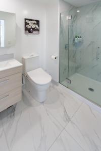 a white bathroom with a toilet and a shower at Large trendy 3 Bedroom Residence, Central City in Christchurch