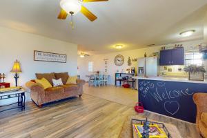 a living room with a couch and a kitchen at Fly Inn Cottage in Rhome