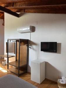 a room with a tv on a white wall at Armagrandi Hotel Bozcaada-Special Category in Bozcaada