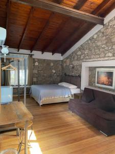 sypialnia z łóżkiem i kamienną ścianą w obiekcie Armagrandi Hotel Bozcaada-Special Category w mieście Bozcaada