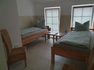 1 dormitorio con 2 camas, sofá y silla en Pauline, en Loxstedt