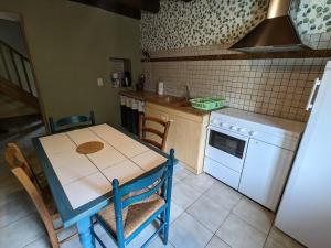 a kitchen with a table and a stove and a sink at Maison de charme en pierres, proche de la nature, idéale pour balades, proche Épinal - FR-1-589-73 in Girancourt +14 photos