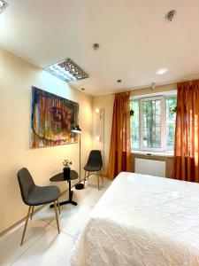 ein Schlafzimmer mit einem Bett, zwei Stühlen und einem Gemälde in der Unterkunft Hostel Good Night in Kharkov