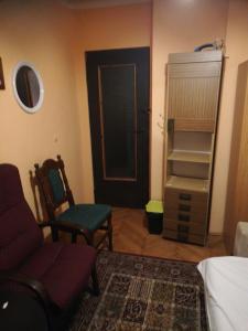 a living room with a couch and a chair and a closet at U Sowy in Kołobrzeg
