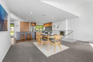 a kitchen and dining room with a table and chairs at Redwoods Getaway in Rotorua