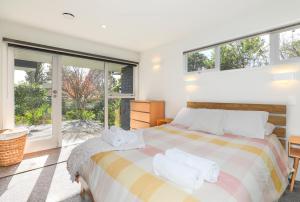 a bedroom with a bed with towels on it at Redwoods Getaway in Rotorua