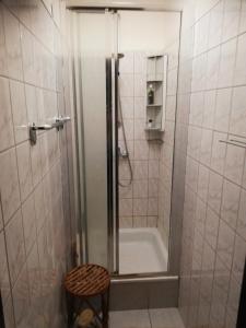 a bathroom with a shower and a tub and a stool at U Sowy in Kołobrzeg