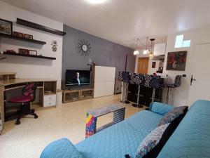 卡斯泰爾諾萊萊的住宿－L'oasis paisible，客厅配有蓝色的沙发和电视