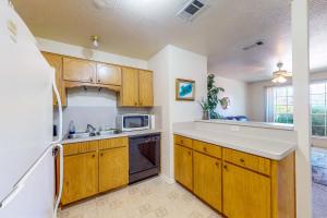a kitchen with wooden cabinets and a sink at It's Always Sunny in Killeen in Killeen