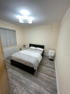 1 dormitorio con 1 cama y ventilador de techo en Modern 4-bedroom entire house with Garden en Uxbridge