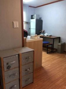 Zimmer mit einer Küche mit einer Theke und einem Schreibtisch in der Unterkunft SoGoBe Pension in Jeju-do