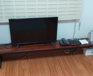una TV a schermo piatto seduta sopra un tavolo di legno di SoGoBe Pension a Jeju